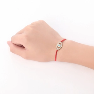 Detail of red cord braided bracelet with gold Evil Eye charm and sparkling crystal pavé