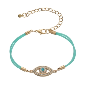 Detail view of turquoise rope bracelet with gold evil eye charm and lobster clasp