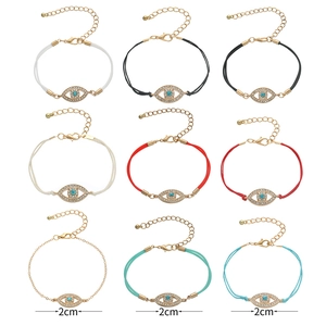 Collection of nine evil eye bracelets in woven cord and gold metal chain link styles