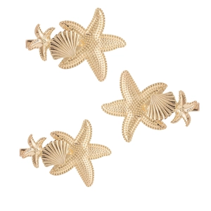 Detailed view of three gold starfish and seashell hair pins with pearl textures