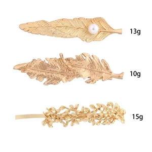Trois barrettes dorées avec plumes, feuilles et perles, poids 10g à 15g par pièce