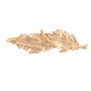 Barrette à cheveux dorée en forme de feuille avec texture détaillée sur fond blanc pur