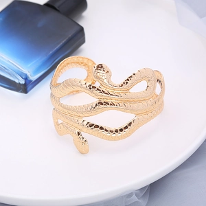 Detail van een gouden slangenarmband met fijne schubstructuren en een glanzende afwerking