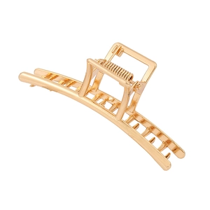 Pinza de pelo de metal dorado con mango rectangular sobre fondo blanco neutro