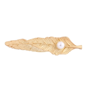 Barrette à cheveux plume dorée élégante avec perle blanche sur fond blanc immaculé