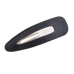 Detailed close-up of a black faux leather teardrop hair clip with silver metal BB grip