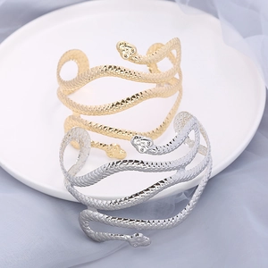 Punk style snake arm cuff bracelet in gold and silver finish with detailed scale texture