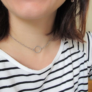 Minimalist silver geometric circle pendant necklace worn by a model on a fine chain