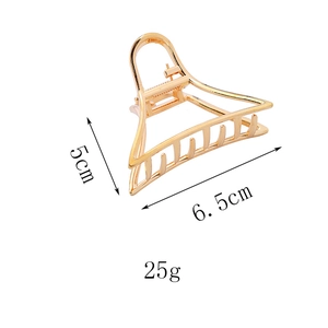 Détail de la pince à cheveux triangle dorée montrant les dimensions 6,5 cm et 5 cm de haut