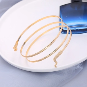Gros plan détaillé d'un bracelet de bras spirale serpent doré avec textures gravées