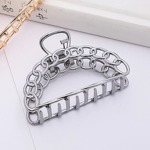 Detail view of large silver metal hair claw clip with hollow chain design and strong spring