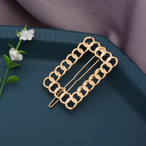 Barrette dorée élégante en forme de chaîne sur un plateau bleu avec fond en soie