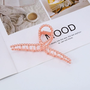 Elegant rose gold twisted metal hair claw clip displayed on a minimalist lifestyle magazine