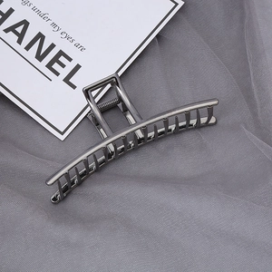 Détail d'une pince à cheveux en métal gris fusil avec ressort solide et design épuré