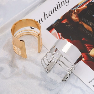 Modern minimalist open wide metal bangles in gold and silver finish on white fabric