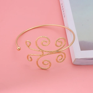 Bohemian style golden open arm cuff bracelet with intricate scroll spiral patterns