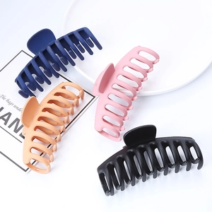Grandi mollette per capelli opache in blu, rosa, beige e nero su un vassoio bianco