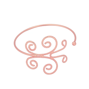 Detail showing the rose gold open bangle with intricate filigree texture and scroll patterns