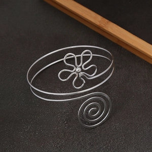 Détail d'un bracelet de bras en métal argenté avec motif fleur et spirale de style ethnique