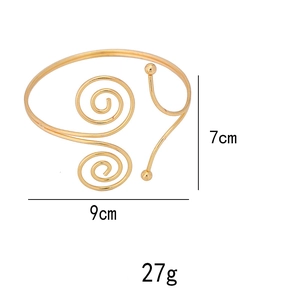 Detailed view of adjustable golden spiral arm cuff with dimensions 9cm width and 7cm height