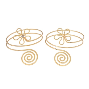 Détail de bracelets de bras dorés en spirale avec filigrane et motifs floraux délicats