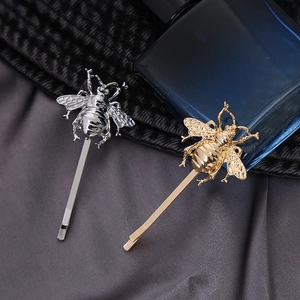 Elegant gold and silver bee hair clips set with realistic insect design on satin fabric