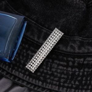 Barrette rectangulaire argentée avec quatre rangées de strass brillants sur denim