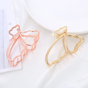 Elegant hollow butterfly hair claw clips in gold and rose gold on white silk fabric
