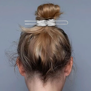 Silver feather hair pin hair accessory worn on a stylish low bun for elegant styling