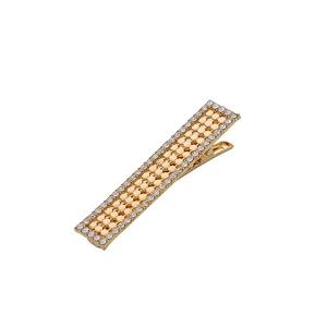 Barrette rectangulaire dorée avec quatre rangées de strass blancs étincelants sur blanc