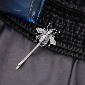 Detailed close-up of a silver metal bee hair clip showing intricate wing textures and finish