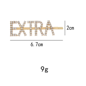 Detailed view of EXTRA letter hair clip with sparkling white rhinestones on gold finish