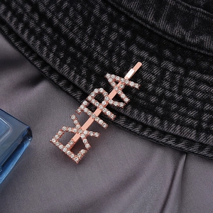 Elegant rose gold hair clip with EXTRA rhinestone lettering on a stylish black hat