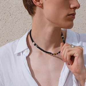 Heren kralenketting met tijgeroog en zwarte matte stenen op het model