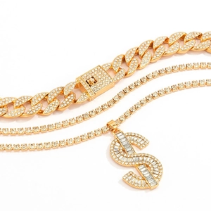 Close-up of iced out Cuban link chain with gold dollar sign pendant and tennis chains