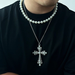 Detail of men's layered necklace featuring a silver cross pendant with pearl inlays