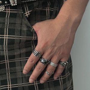 Gothic punk ring set with skull motif and black gemstone on male model hand