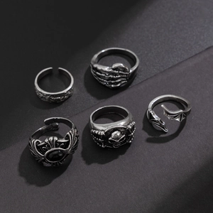 Detailed close-up of gothic skull and bat wing rings set with black gemstone