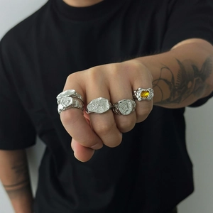 Detailansicht von fünf Hip-Hop Ringen mit Felsentextur und gelbem Edelstein für Herren
