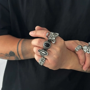 Détail de bagues gothiques punk en argent avec tête de mort, pierre noire et gravure vintage