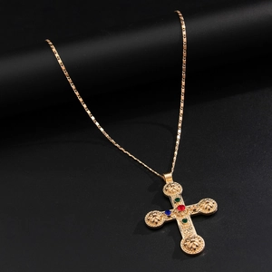 Detailed close-up of a vintage golden cross pendant with colorful rhinestone inlay