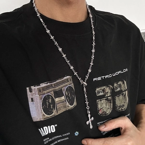 Close-up of hip hop silver cross necklace with star-link chain on male model