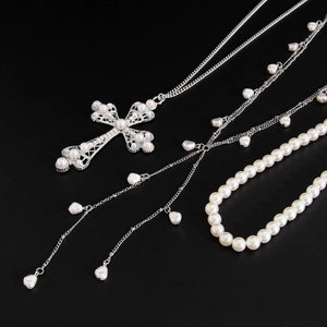 Vue détaillée du pendentif croix hip hop avec perles baroques et chaînes argentées