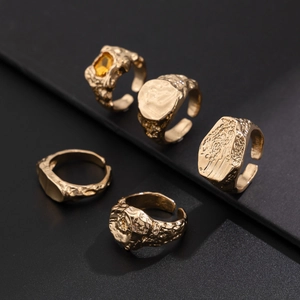 Detailansicht von fünf Herrenringen in Gold mit Lavatextur und gelbem Schmuckstein