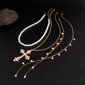 Détail d'un ensemble de colliers dorés avec grand pendentif croix en perles