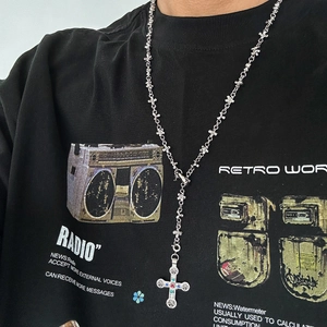 Detail of hip-hop cross necklace with colorful gems on link chain and cross pendant