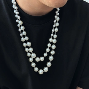 Double-layered white pearl necklace for men and women showing on a model's neck