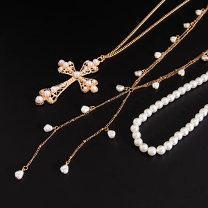 Vue détaillée de bijoux hip-hop avec pendentif croix dorée et perles blanches