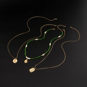 Détails des pendentifs vintage en or avec coquillage et chaîne à perles vertes