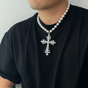 Collier de perles gothique exagéré avec grand pendentif croix argentée porté sur t-shirt noir